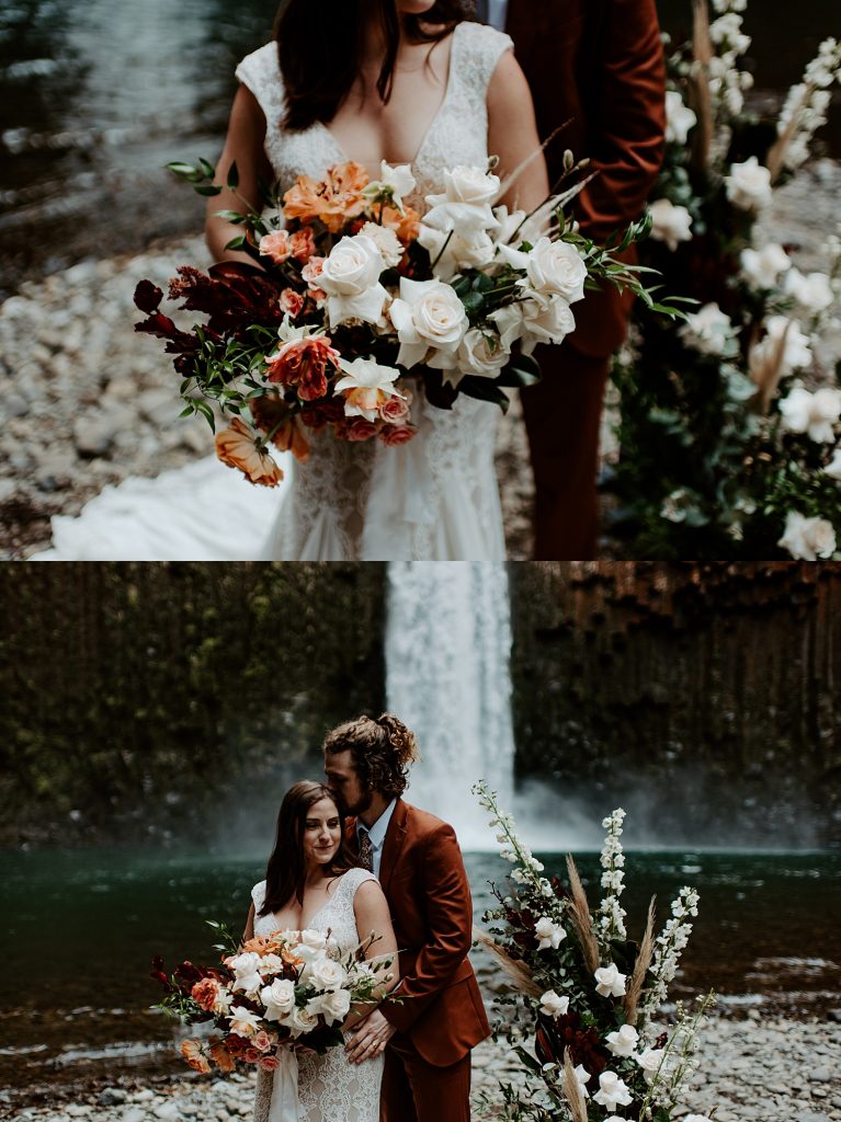 Bride and groom holding a large boho bridal bouquet with whites, pinks, greenery, and orange florals.