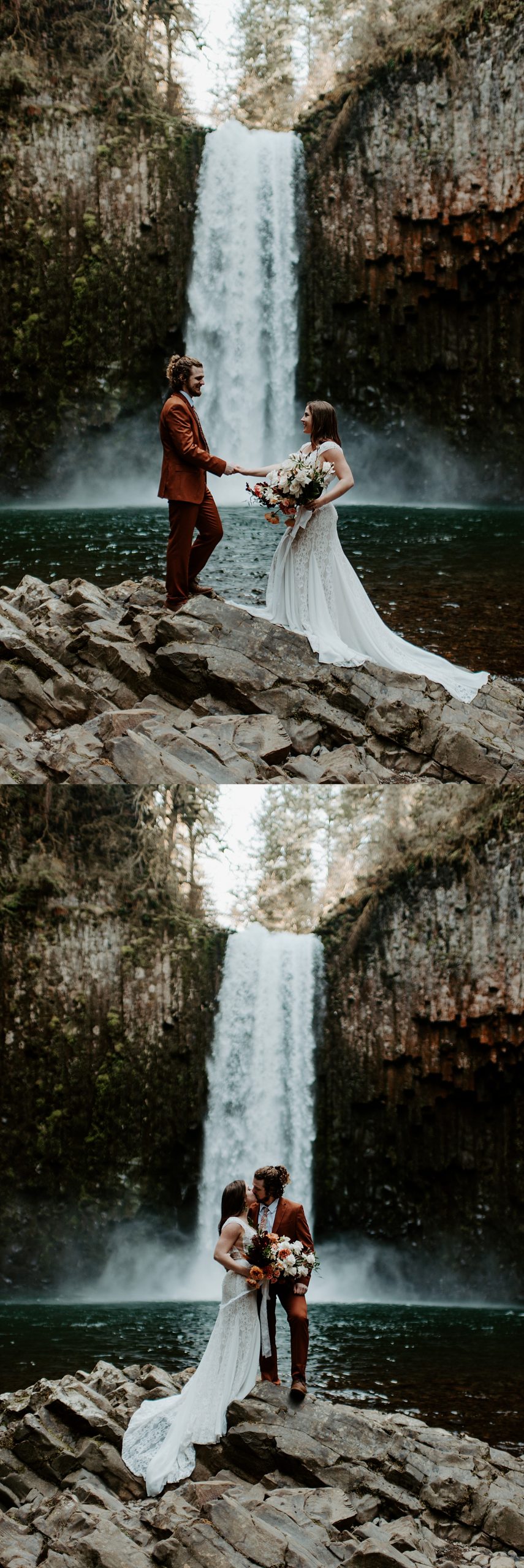 Bride and groom posing on large rocks in front of an Oregon waterfall wearing a lacey wedding dress and a burnt orange suit, and holding a boho bridal bouquet.