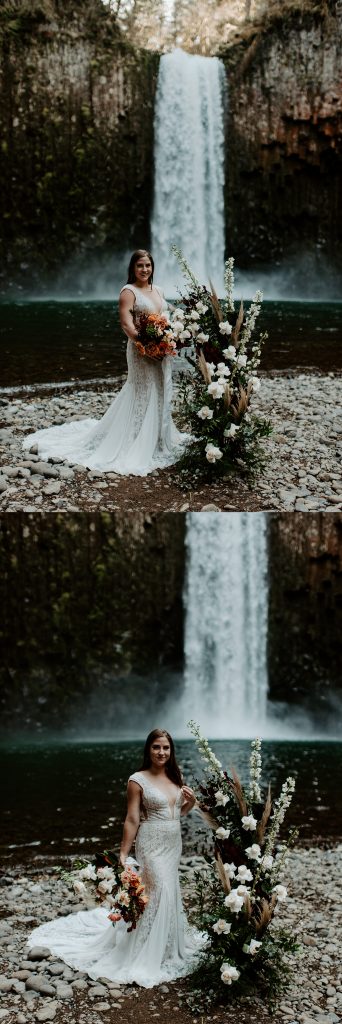 Bride portraits in front of a waterfall with a boho, lacey dress and a neutral colored floral bouquet.