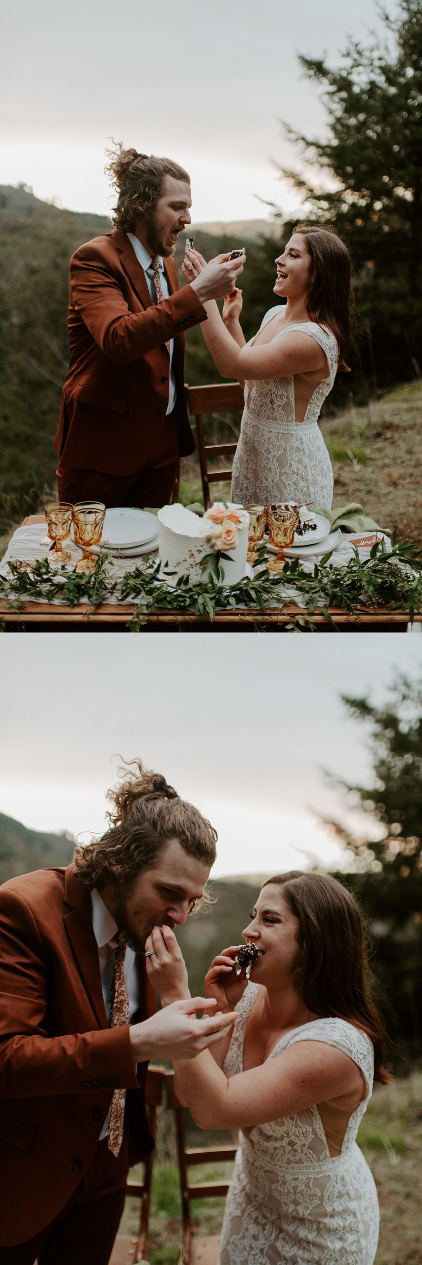 Bride and groom feeding each other cake in front of a small forest and earthy-toned tablescape with a view of a valley behind them.