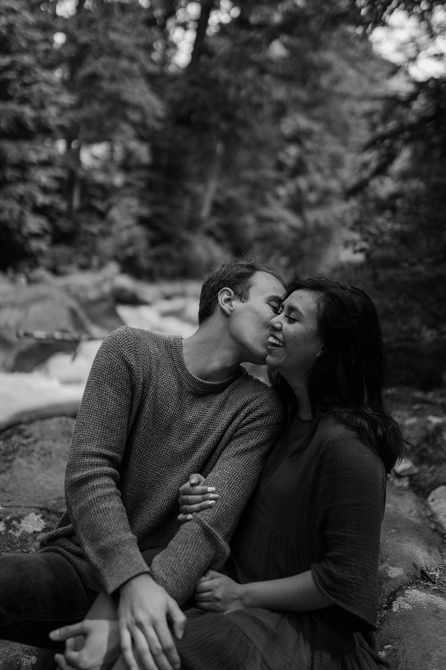 Black and white photo of a couple laughing and kissing