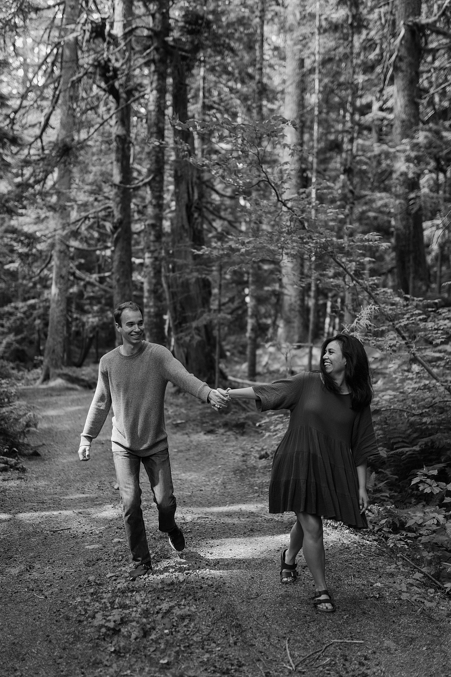 Black and white photo of a couple holding hands and walking