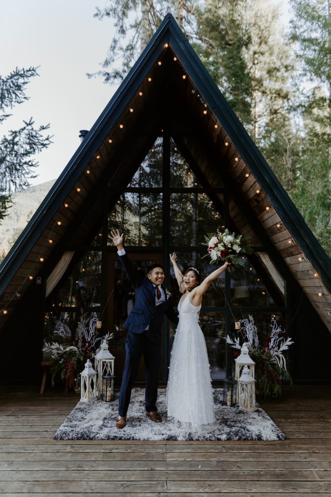 Couple cheering in front of an Airbnb for their elopement at Mount Rainier