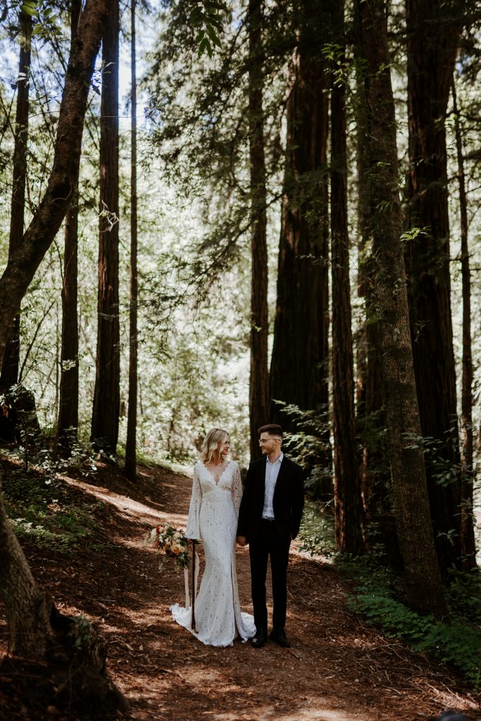 Boho eloping couple standing on a trail in Redwoods National Park, California