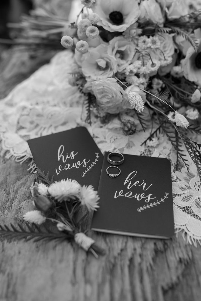 elopement details with a vow book, bouquet, and rings