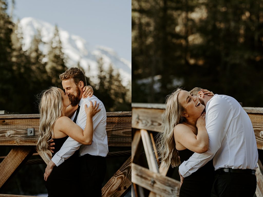 engaged couple kissing on a bridge with Mount Rainier in the background