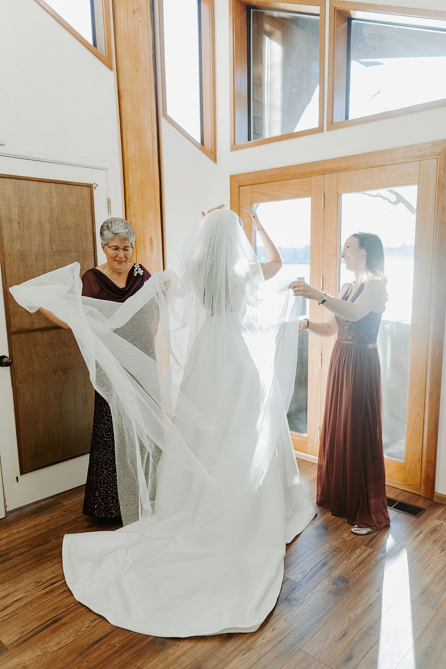 Bride putting on her wedding veil