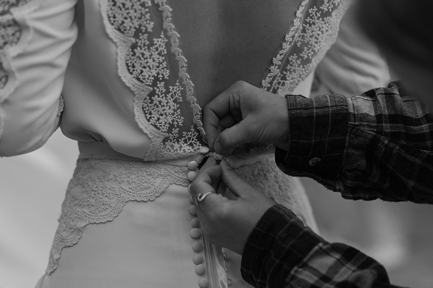 Bride getting her wedding dress buttoned up