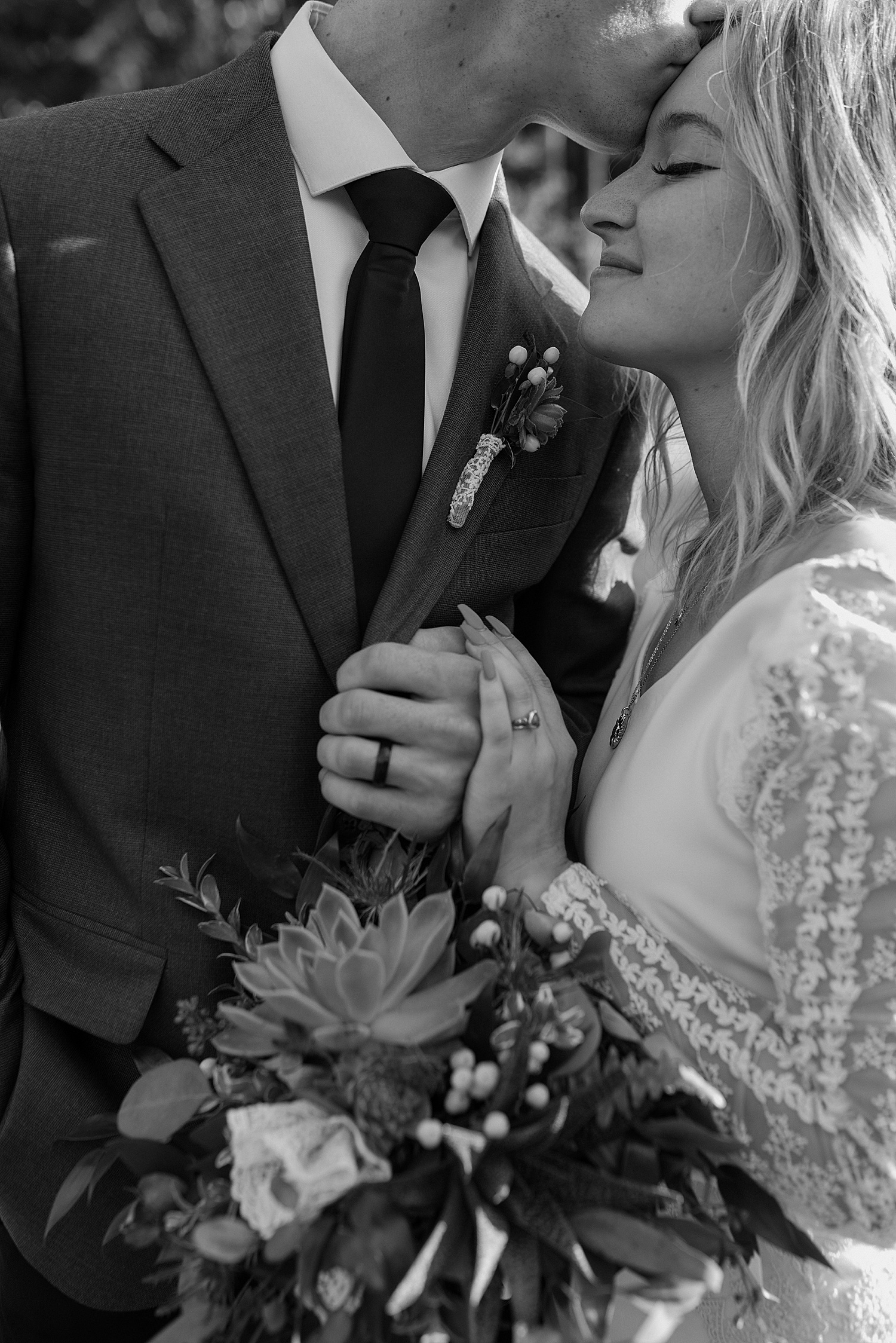 black and white image of a couple with their wedding rings