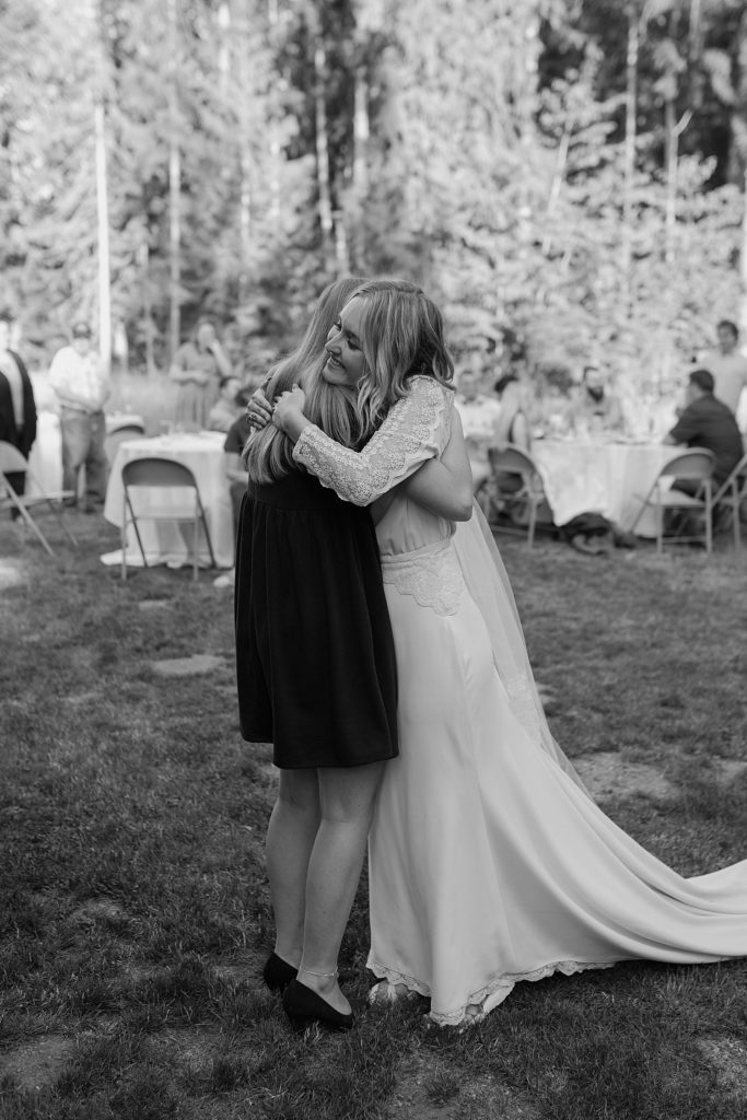 black and white image of a bride hugging her sister