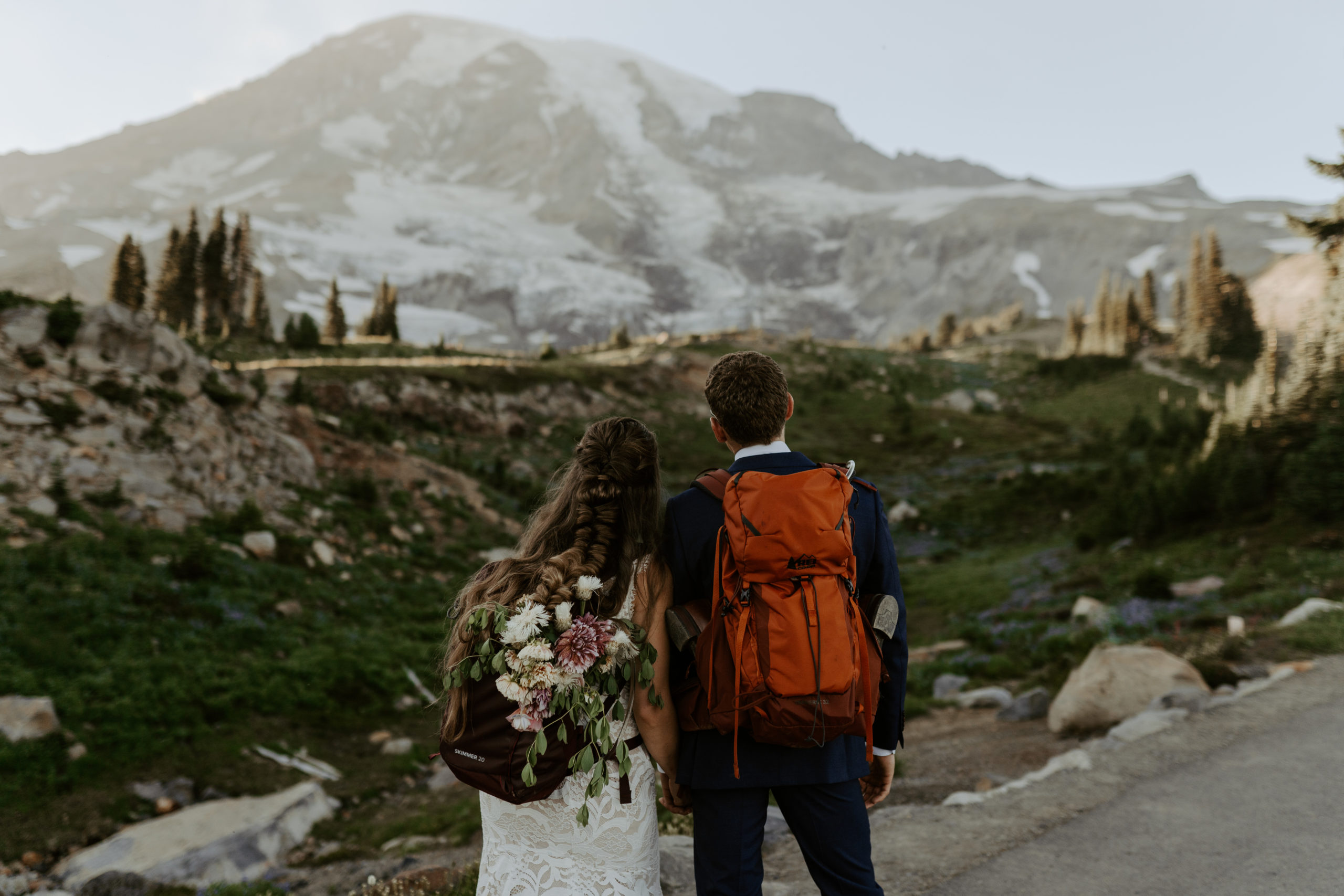 eloping couple hiking with hiking backpacks at Mount Rainier