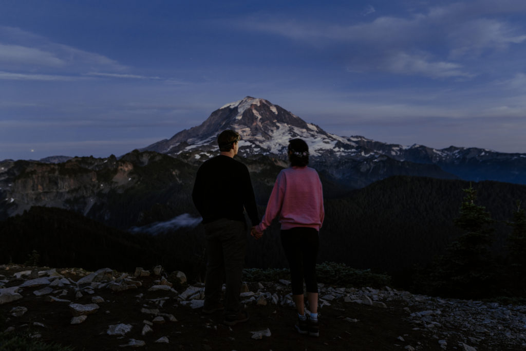eloping couple with headlamps stargazing and looking at Mount Rainier after sunset