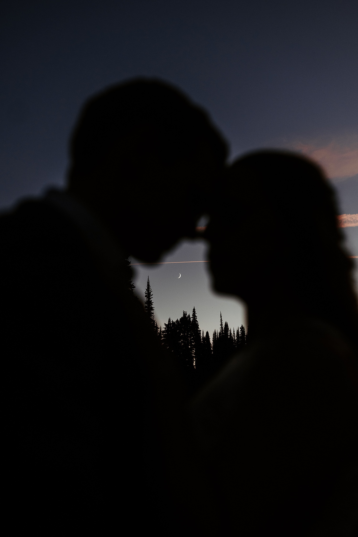 night photo of bride and groom with the moon