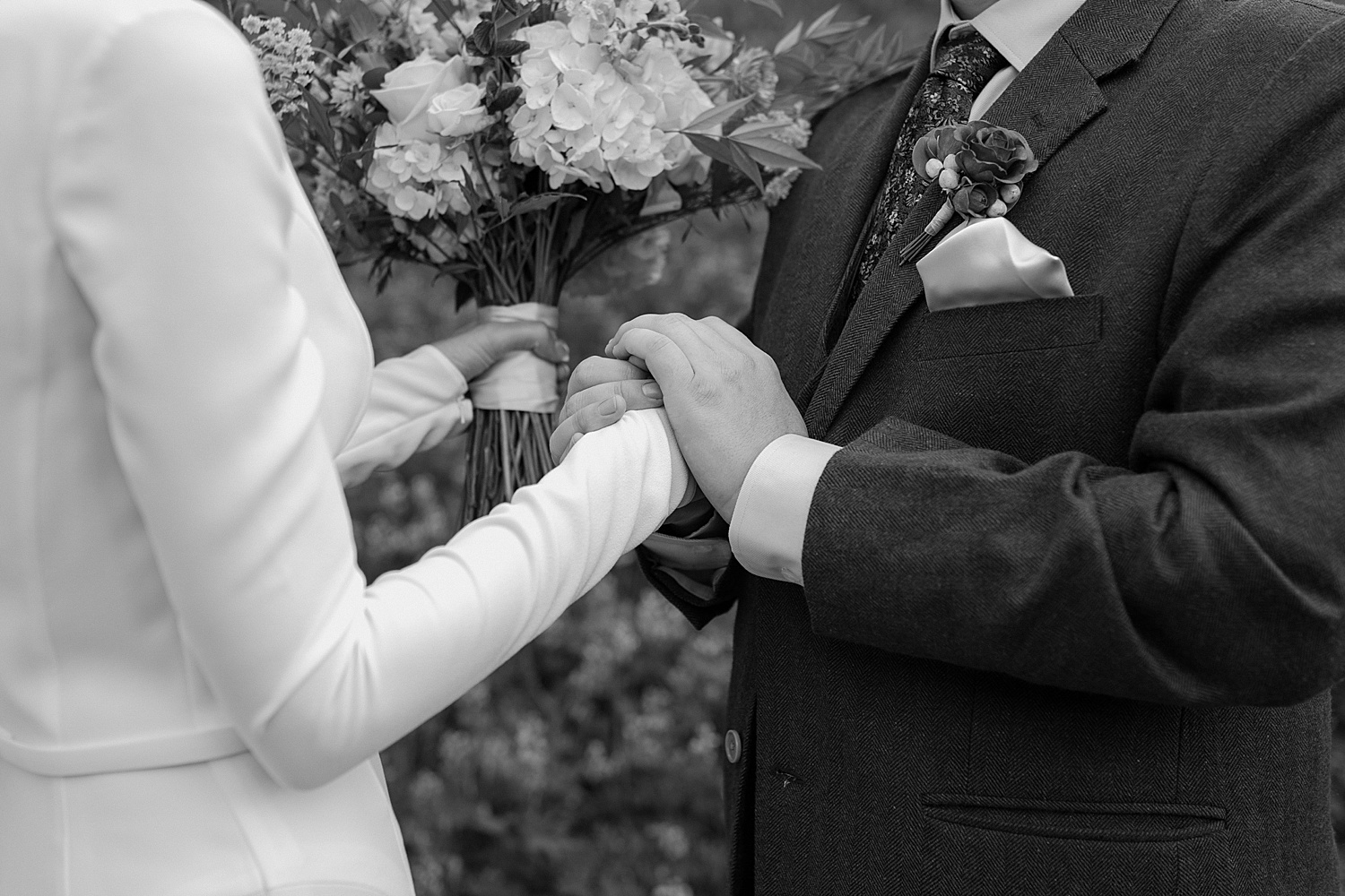 black and white photo of a bride and groom with floral bouquet