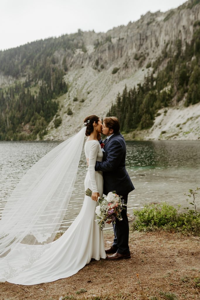 firsrt kiss between bride and groom at a lake