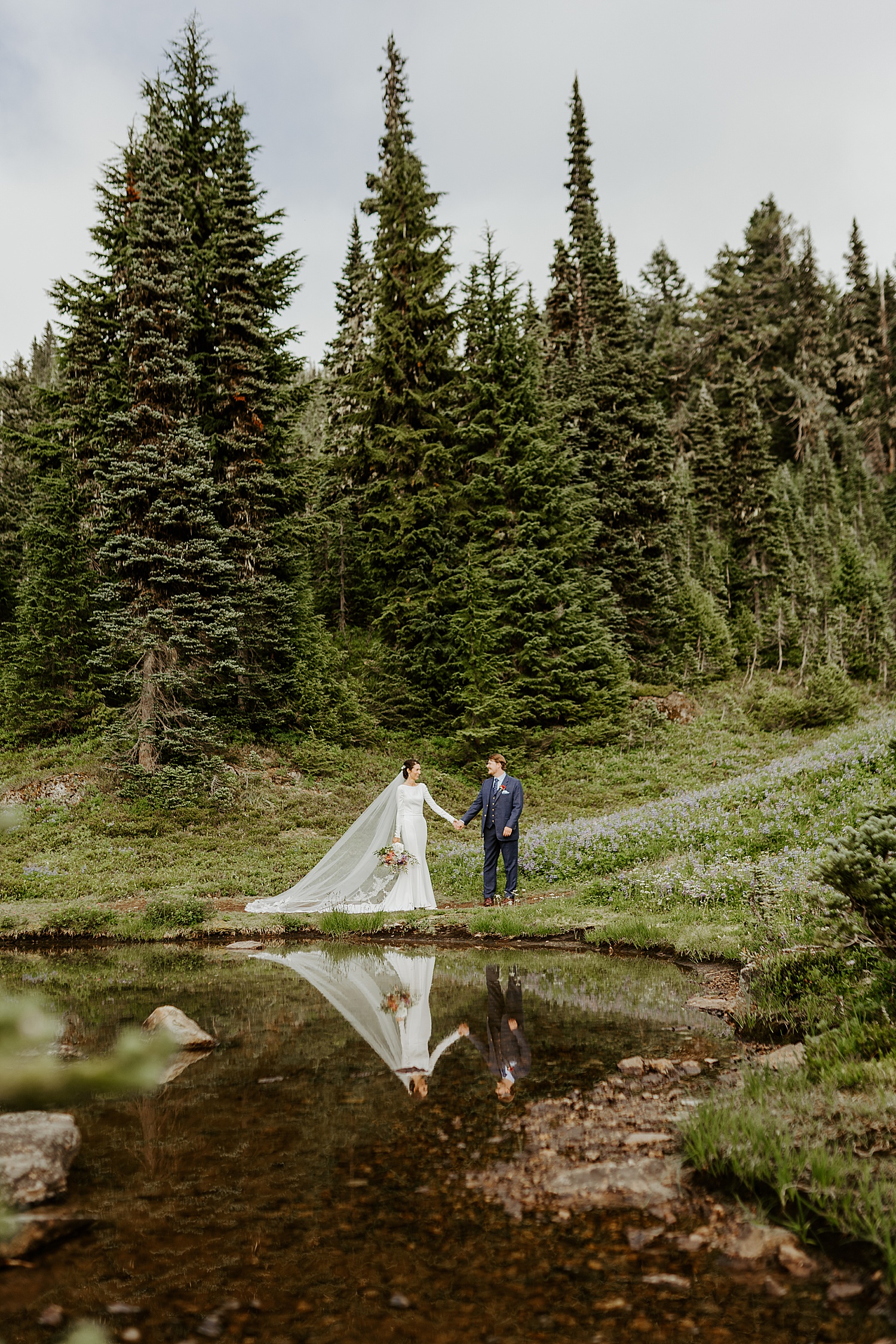 reflective photo of a bride and groom at a lake