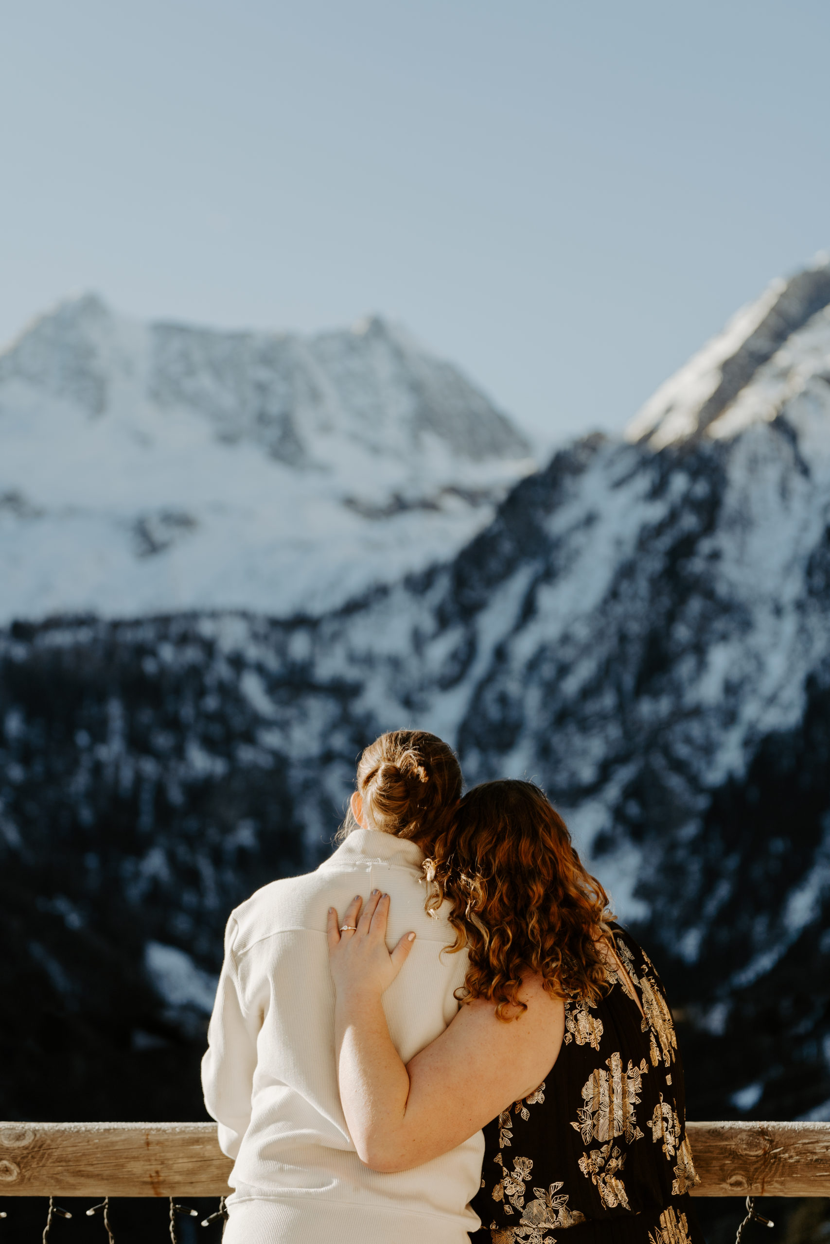 LGBTQ couple hugging and looking at the Dolomites mountain range