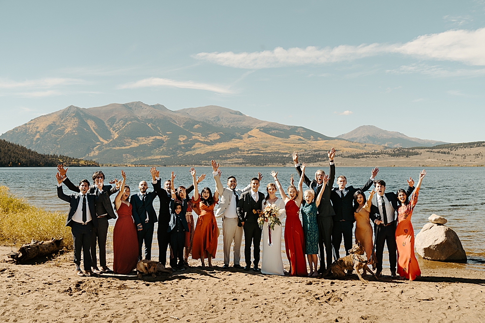 Family and friends all cheering with their arms in the air for the bride and groom that just got married at Twin Lakes in Colorado. 