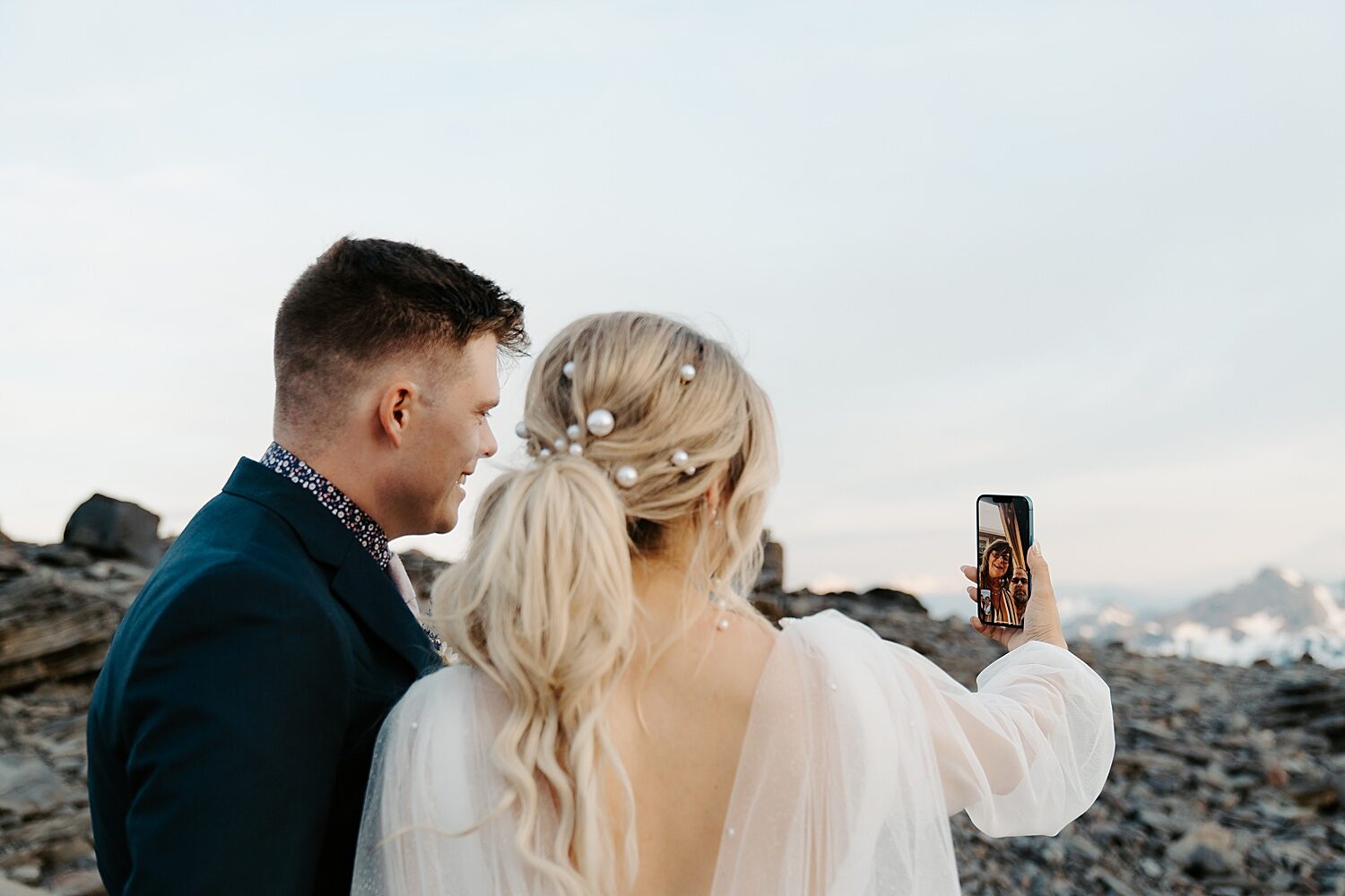 Bride and groom FaceTiming parents on their elopement day at Mount Rainier National Park. 