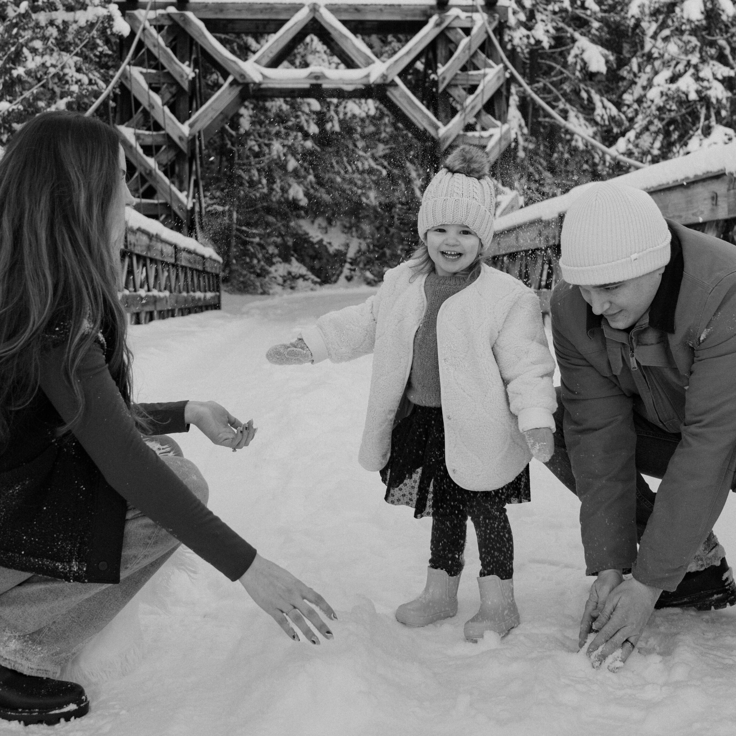 Black and white family photo on a bridge with snow in Mount Rainier National Park.