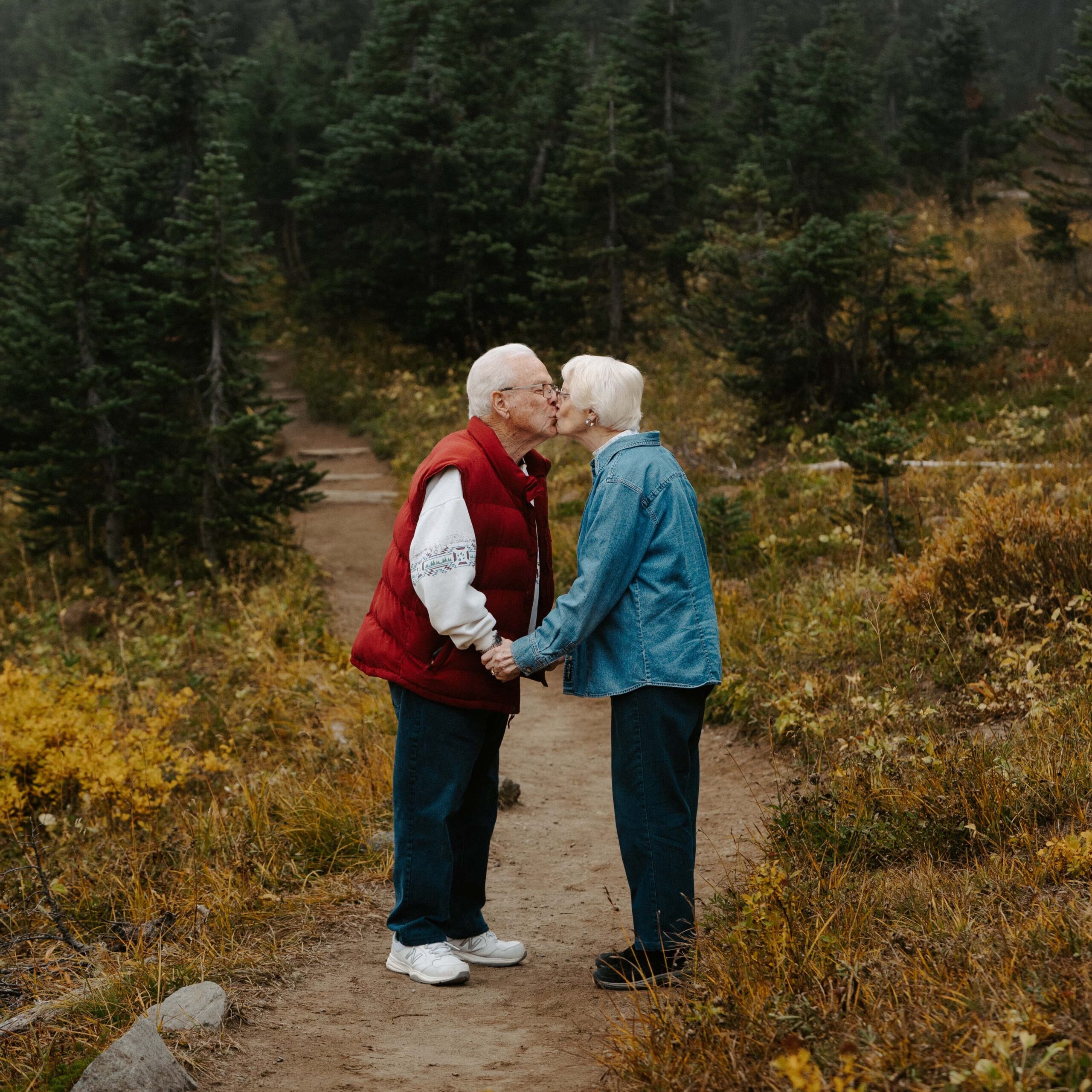 A senior couple kissing on a trail in the fall at Mount Rainier. 