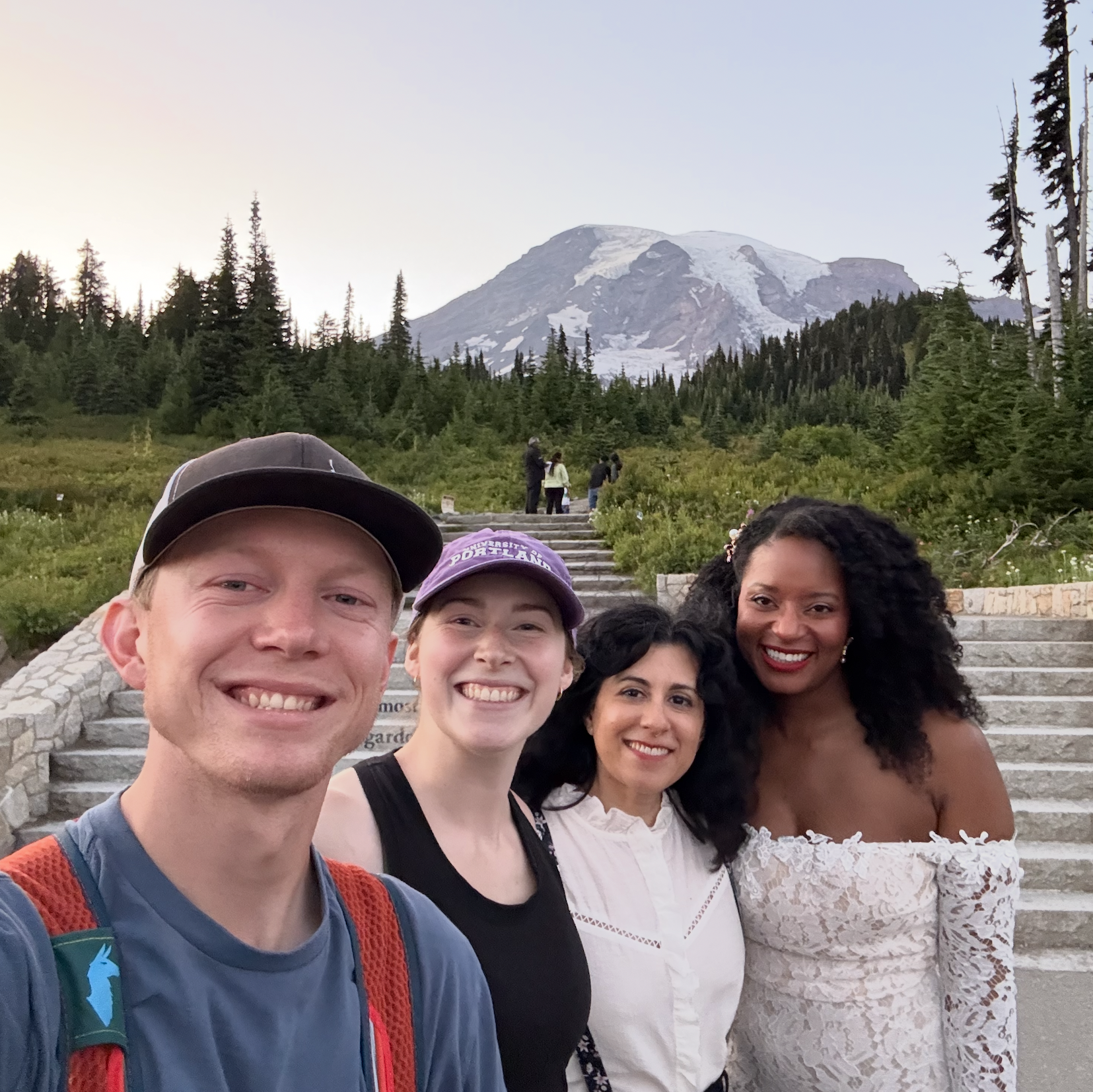 Adam and Hannah of Venture to Elope taking a selfie with two brides in wedding attire that got eloped at Mount Rainier National Park. 
