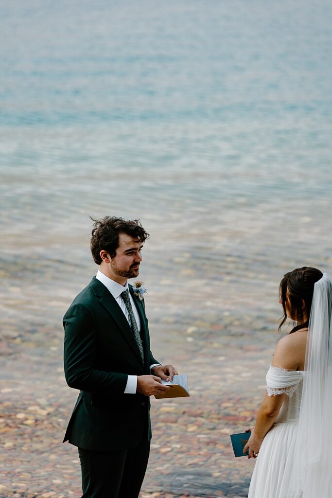 Groom saying vows to his bride at their intimate Lake McDonald elopement in Glacier Park. 