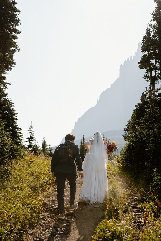 Bride and groom hiking at Logan Pass in Glacier Park. 