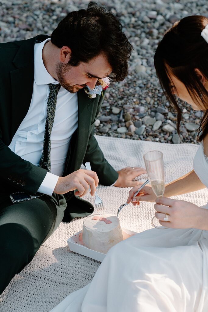 Bride and groom using forks to get bites of their small elopement cake. 