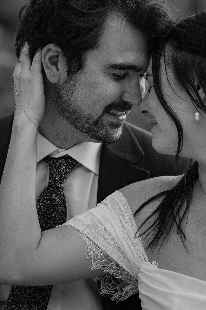 Black & white of bride and groom closing their eyes and resting their foreheads together. 