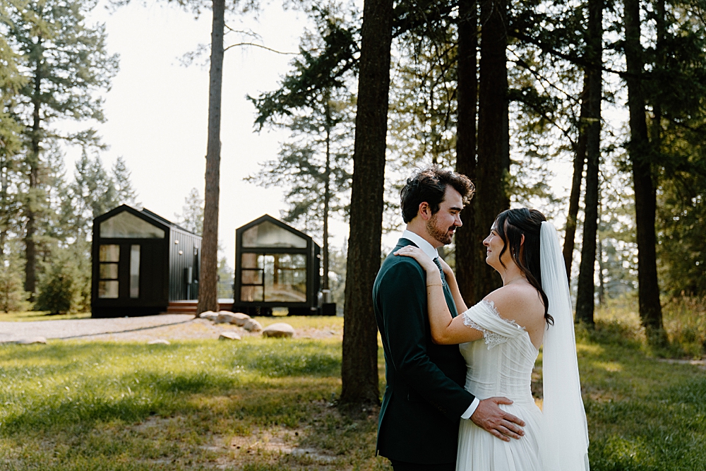 Bride and groom portrait with tiny cabins in the background in Montana