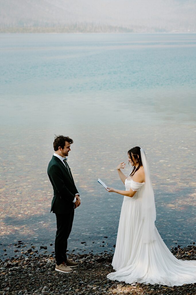 Bride and groom saying vows along Lake McDonald in Glacier National Park