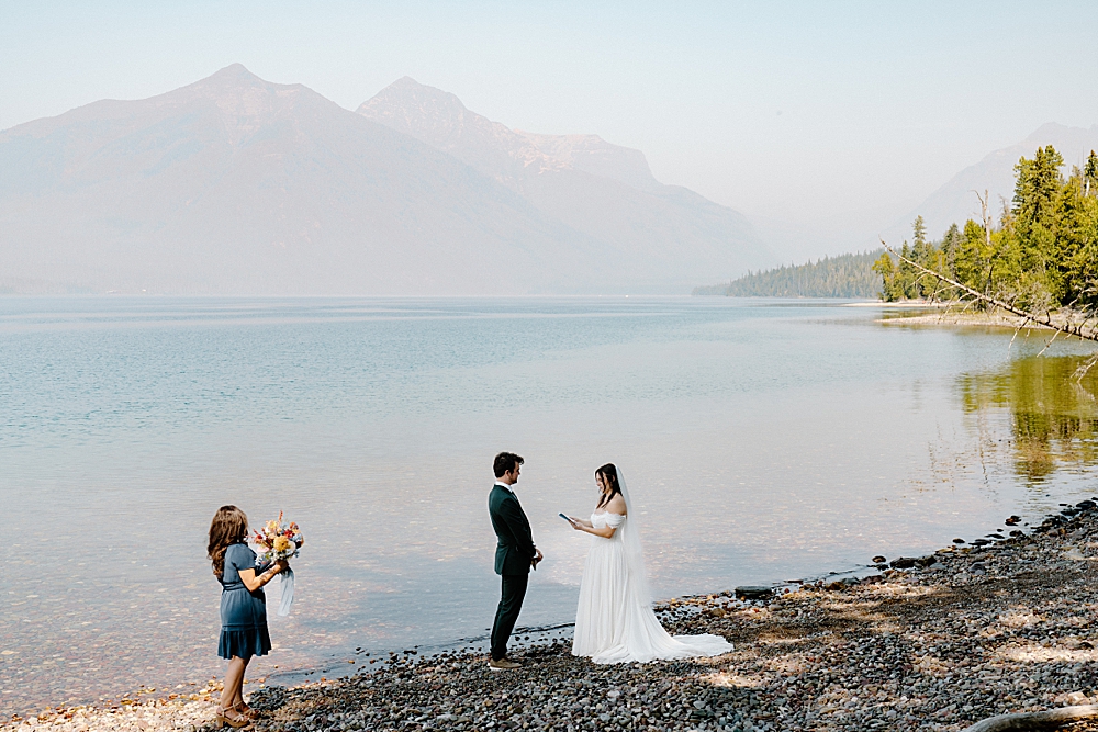 Bride and groom saying vows along Lake McDonald in Glacier National Park