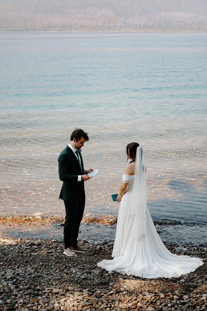 Bride and groom saying vows along Lake McDonald in Glacier National Park