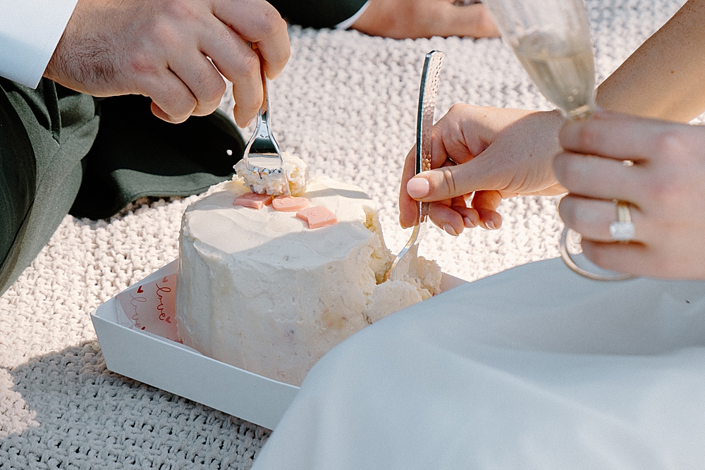 Up-close of bride and groom's forks as they dig into a small wedding cake