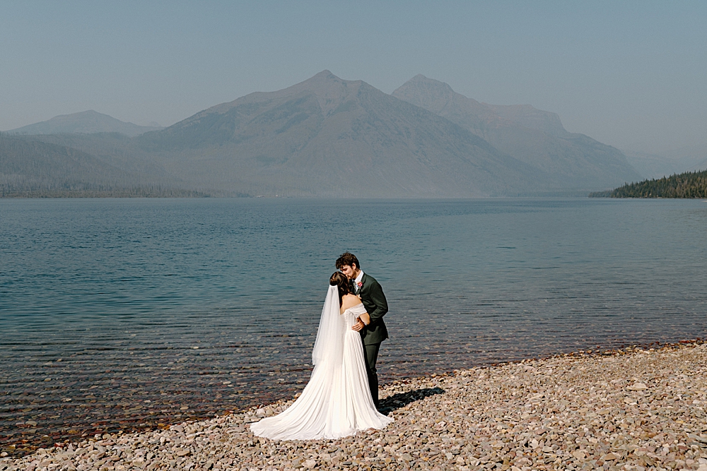Montana elopement photographer captured bride and groom kissing at Lake McDonald after their elopement ceremony