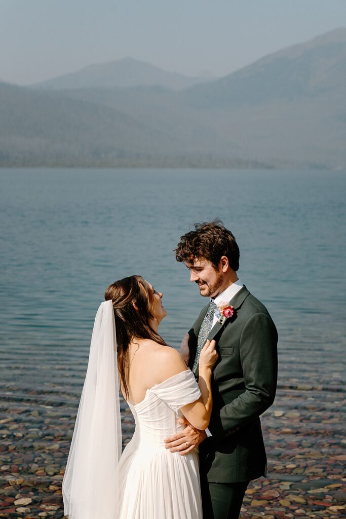 Sunny image of bride and groom in front of Lake McDonald