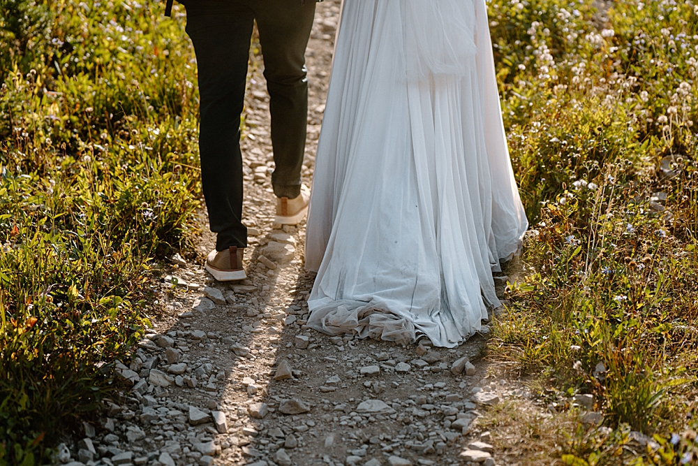 Dirty elopement dress train while walking on a hiking trail