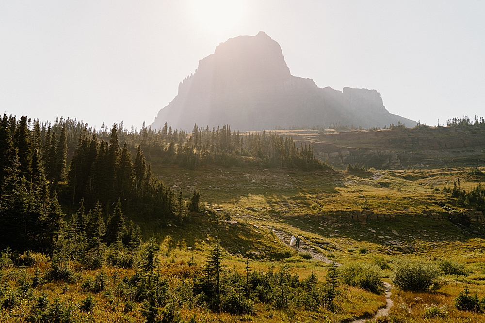 Far away image of bride and groom hiking in Glacier Park