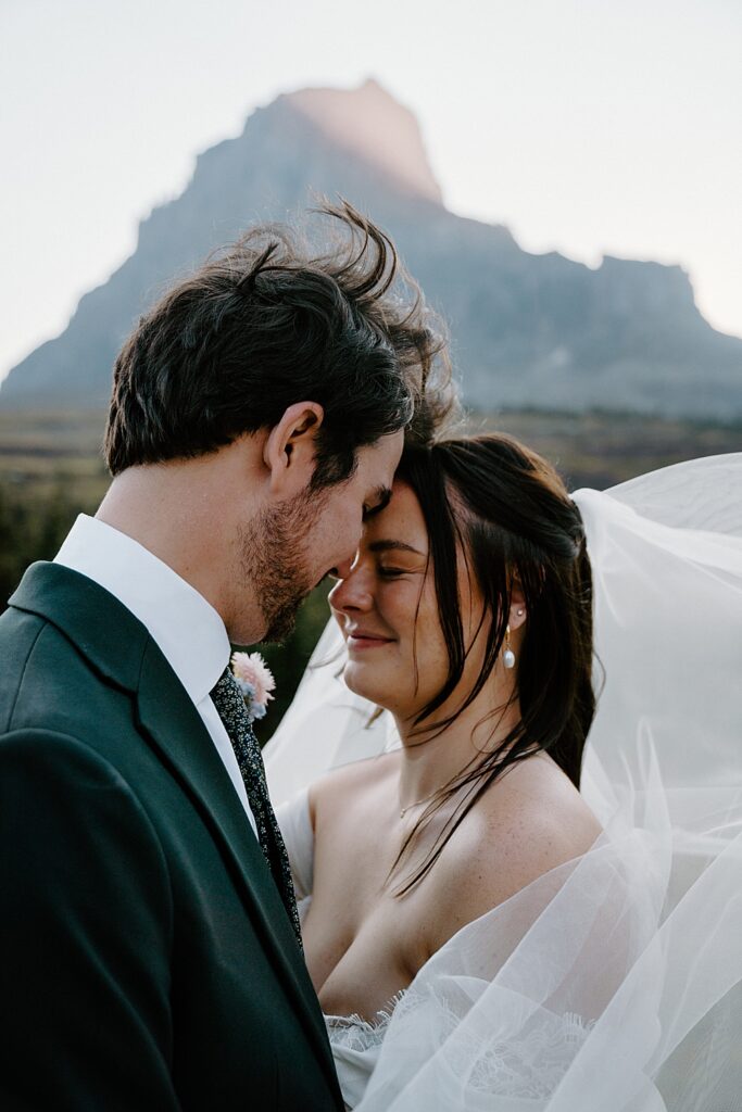 Logan Pass elopement portrait with bride and groom resting foreheads together