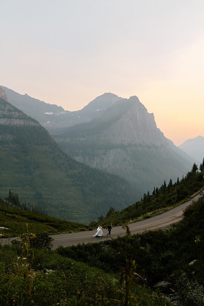Bride and groom elopement portrait of them running on the Going-to-the-Sun Road in Glacier National Park