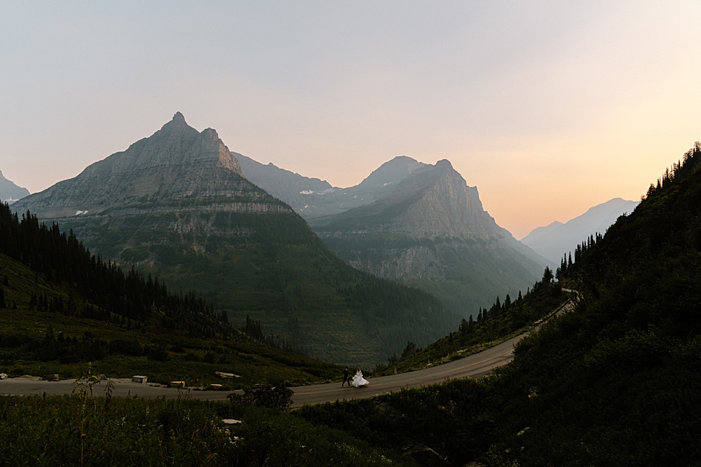 Bride and groom elopement portrait of them running on the Going-to-the-Sun Road in Glacier National Park