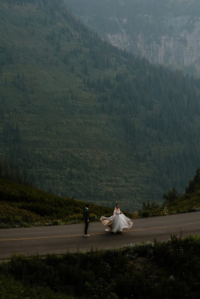 Bride and groom elopement portrait of them running on the Going-to-the-Sun Road in Glacier National Park