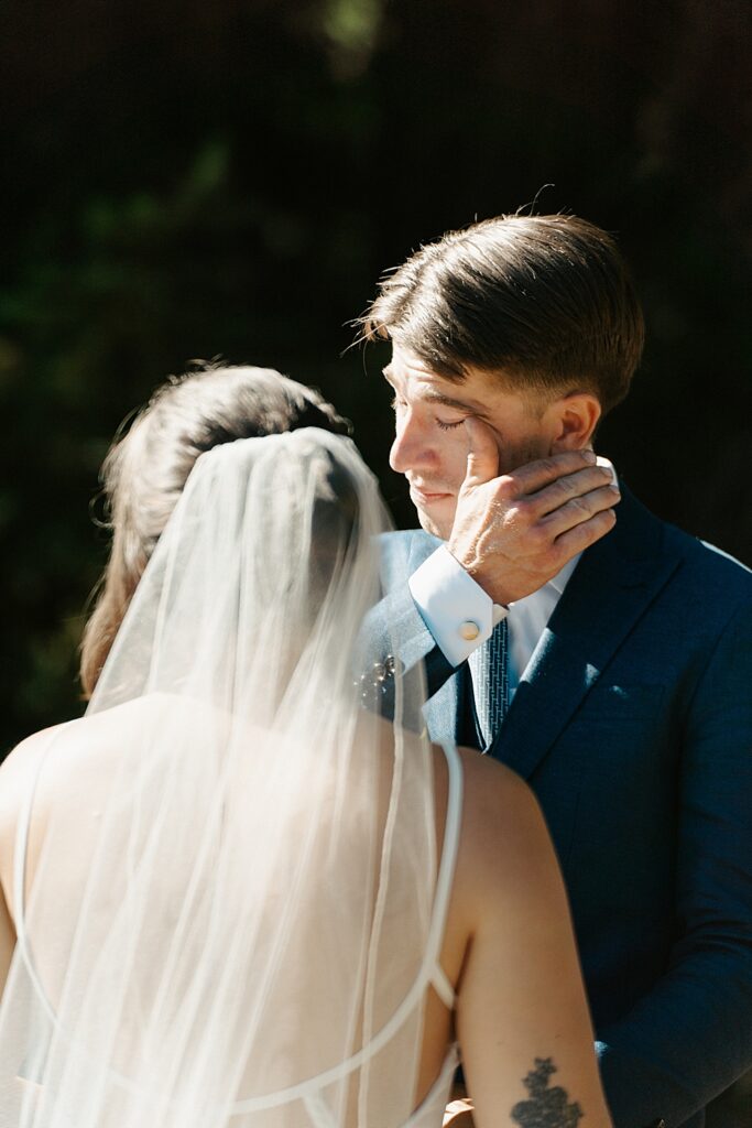 Groom wiping away a tear during a small wedding ceremony along the Cowlitz River in Packwood.
