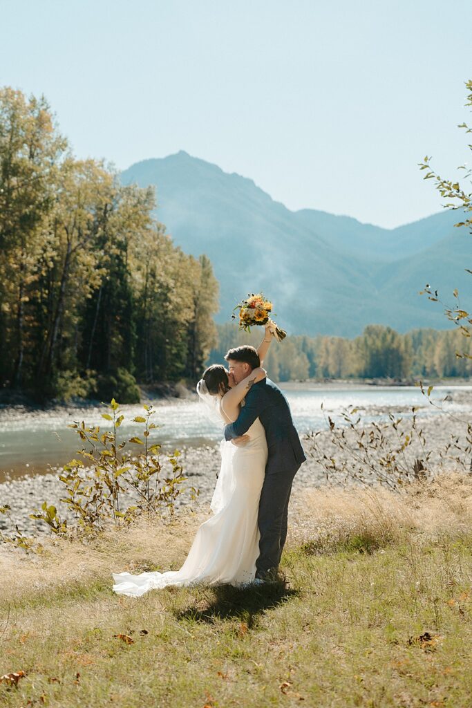 Bride and groom kissing after their small wedding ceremony along the Cowlitz River in Packwood, WA.