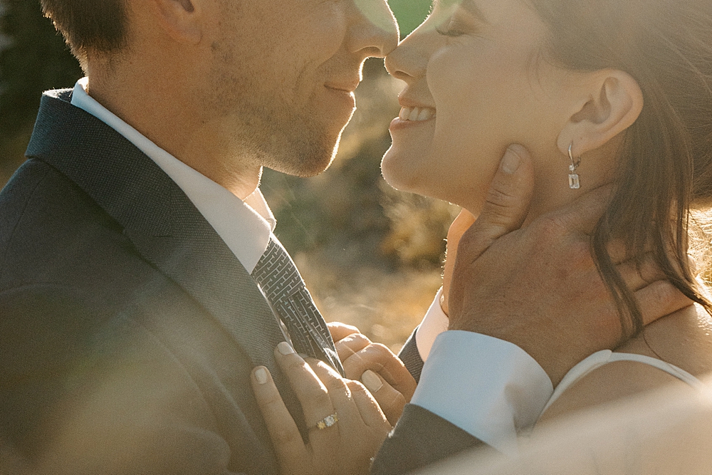 Up close of bride and groom holding each other and nuzzling their noses at their sunset Mount Rainier elopement.