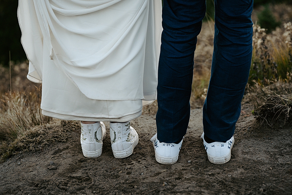 Up close image of bride and groom's hand-embroidered converse with their wedding date and "we do."