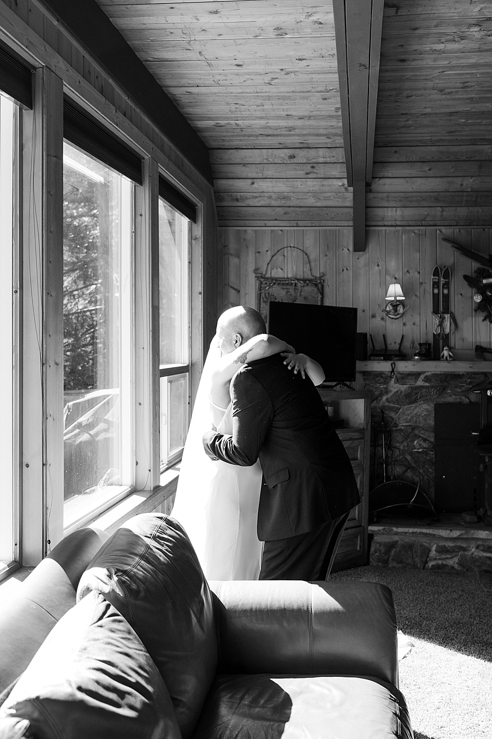 Black & white of a bride and father of the bride hugging after their first look.