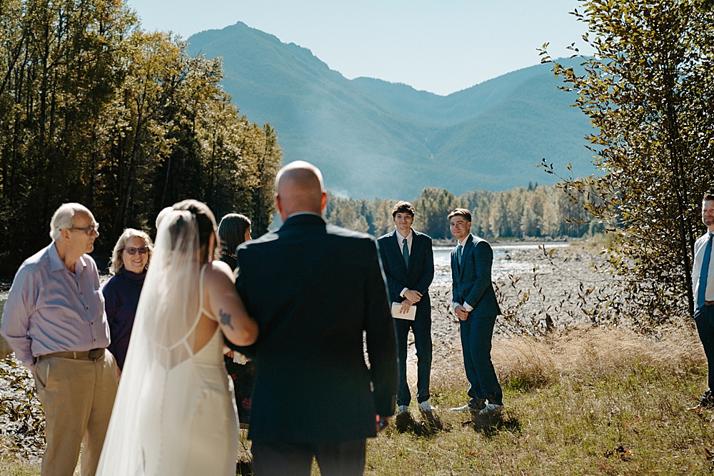 Father of the bride walking bride down the lawn to the groom and his happy reaction to seeing her for the first time.