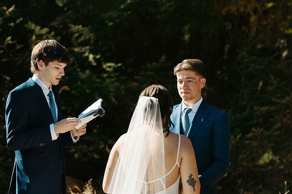 Groom tearing up while looking at his bride during their intimate Packwood Airbnb wedding ceremony.